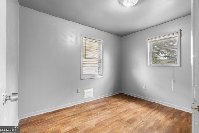 unfurnished room with a wealth of natural light, light wood-style flooring, and baseboards