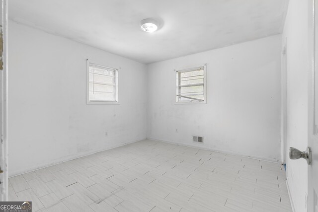 empty room with plenty of natural light and visible vents