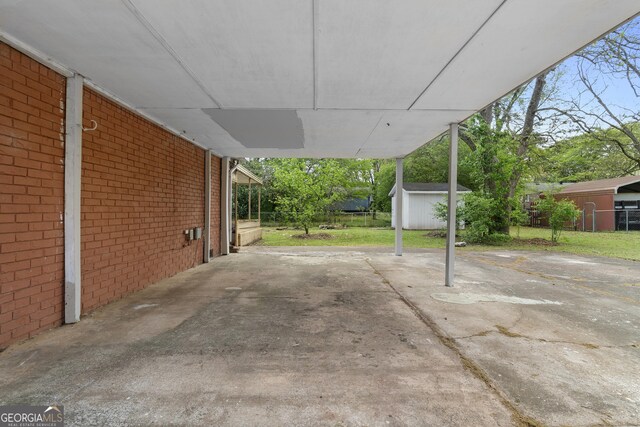 exterior space with a shed, fence, an outdoor structure, and an attached carport