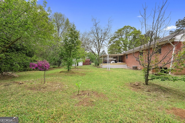 view of yard featuring a shed, central AC unit, and an outdoor structure