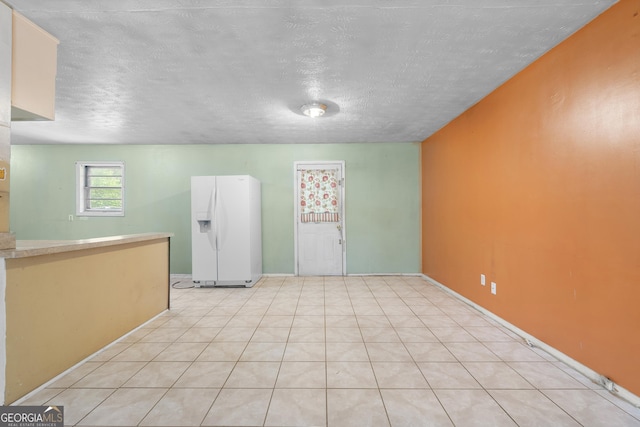 interior space featuring light countertops, a textured ceiling, and white fridge with ice dispenser