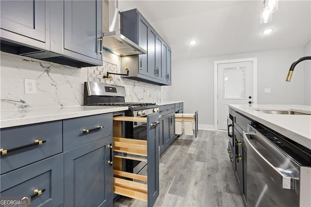 358 Roy St SW, Atlanta, GA 30310 - kitchen with appliances with stainless steel finishes, wall chimney range hood, a sink, tasteful backsplash, and wood finished floors
