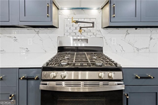 358 Roy St SW, Atlanta, GA 30310 - kitchen with stainless steel range with gas cooktop, light countertops, blue cabinetry, and tasteful backsplash