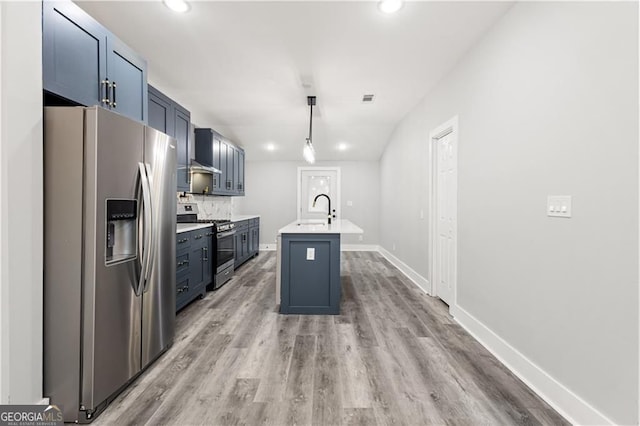 358 Roy St SW, Atlanta, GA 30310 - kitchen featuring stainless steel appliances, light countertops, a sink, light wood-style floors, and a center island with sink