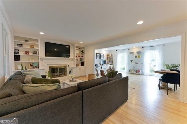 3811 Valley Green Dr, Marietta, GA 30068 - living area featuring a glass covered fireplace, ornamental molding, light wood-type flooring, built in features, and recessed lighting
