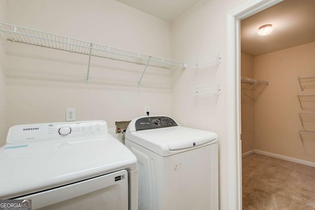 laundry area with light colored carpet, baseboards, separate washer and dryer, and laundry area