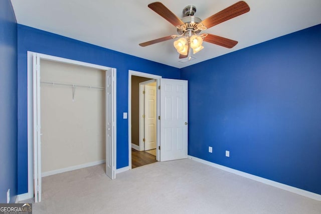 unfurnished bedroom with carpet floors, a closet, a ceiling fan, and baseboards
