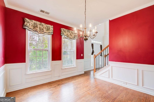 foyer with a wainscoted wall, visible vents, a notable chandelier, wood finished floors, and stairway