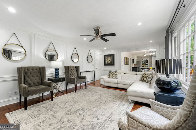 292 Old Rosser Rd, Stone Mountain, GA 30087 - living room with ornamental molding, wood finished floors, ceiling fan with notable chandelier, and a decorative wall