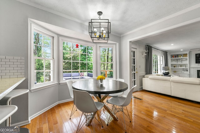 292 Old Rosser Rd, Stone Mountain, GA 30087 - dining room with light wood-style floors, a textured ceiling, crown molding, and an inviting chandelier