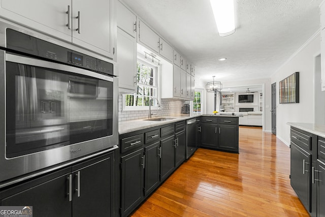 292 Old Rosser Rd, Stone Mountain, GA 30087 - kitchen featuring decorative backsplash, open floor plan, dishwashing machine, a sink, and light wood finished floors
