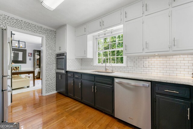 292 Old Rosser Rd, Stone Mountain, GA 30087 - kitchen featuring a sink, ornamental molding, stainless steel appliances, and white cabinetry