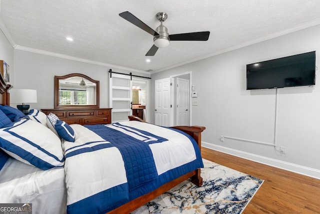 292 Old Rosser Rd, Stone Mountain, GA 30087 - bedroom featuring a ceiling fan, a barn door, wood finished floors, baseboards, and ornamental molding