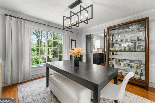 292 Old Rosser Rd, Stone Mountain, GA 30087 - dining space with a textured ceiling, a chandelier, ornamental molding, and light wood-style flooring
