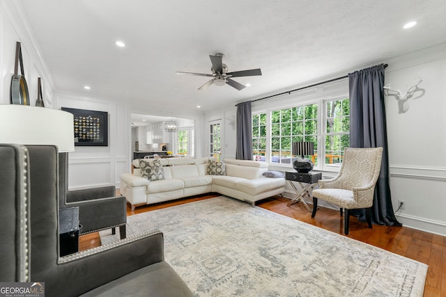 292 Old Rosser Rd, Stone Mountain, GA 30087 - living room featuring crown molding, wood finished floors, ceiling fan with notable chandelier, and a decorative wall
