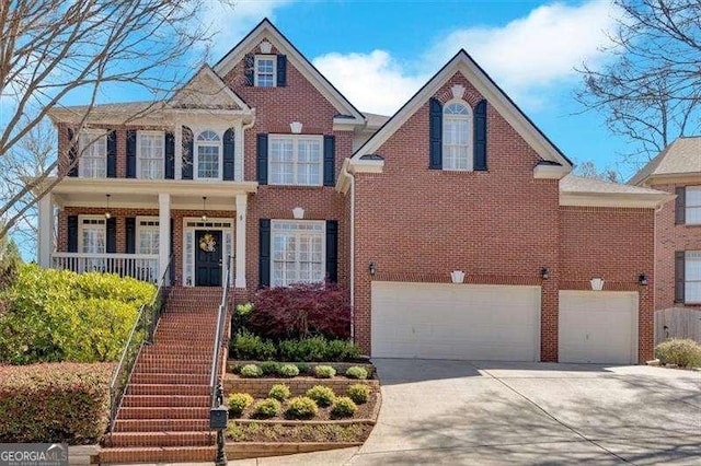 view of front facade with brick siding, an attached garage, driveway, and stairs