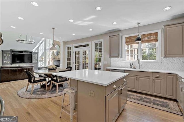 kitchen featuring open floor plan, gray cabinets, light wood finished floors, and a center island