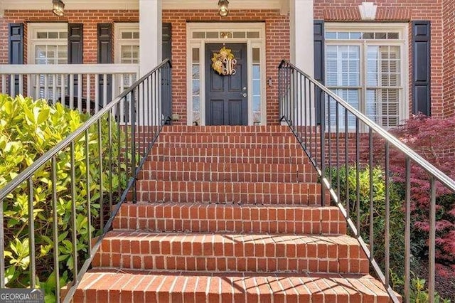 view of exterior entry featuring brick siding