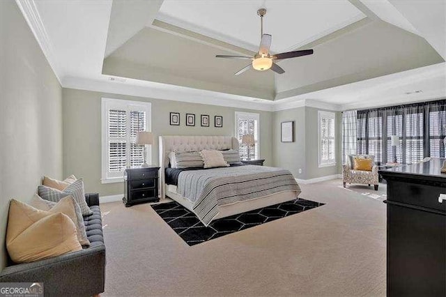 bedroom featuring ornamental molding, a tray ceiling, baseboards, and carpet