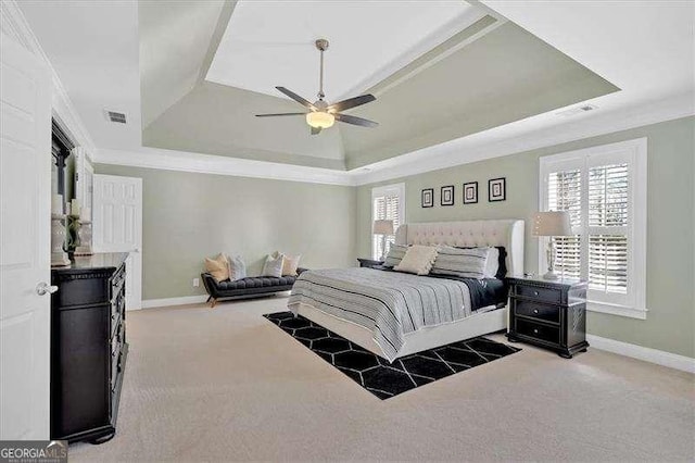 bedroom featuring a tray ceiling, ornamental molding, visible vents, carpet flooring, and baseboards