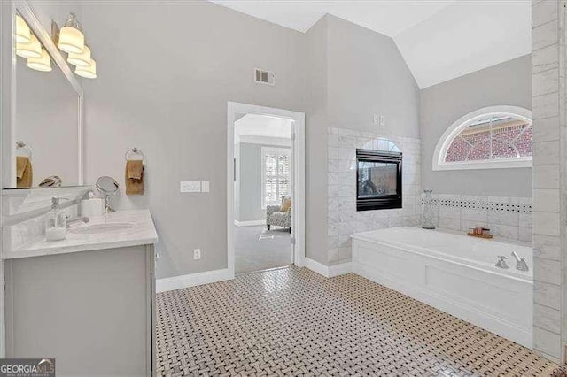 bathroom featuring a healthy amount of sunlight, a garden tub, vaulted ceiling, and visible vents
