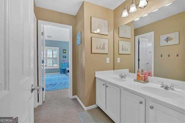 full bath featuring double vanity, baseboards, and a sink