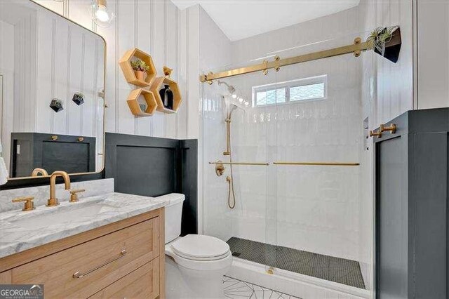 bathroom with toilet, a shower stall, and vanity