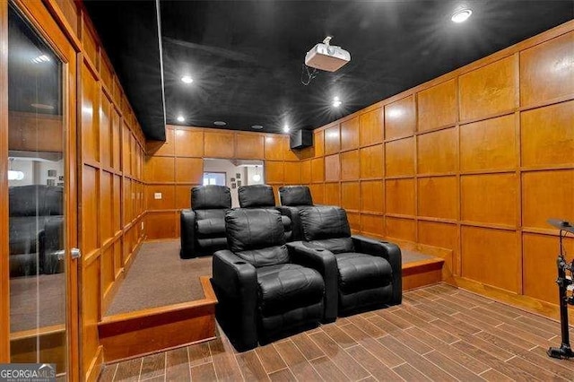 home theater with recessed lighting, a decorative wall, and wood tiled floor