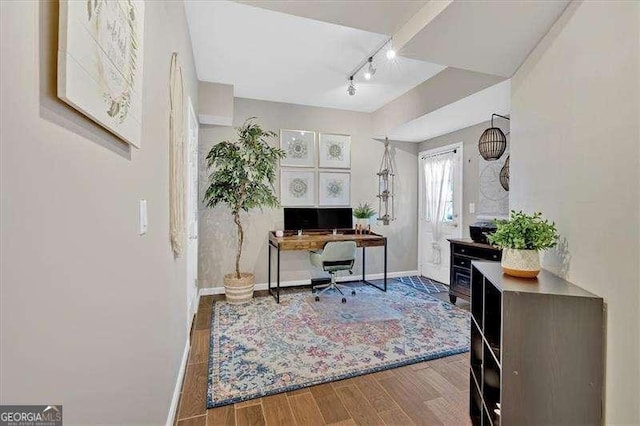 office space featuring track lighting, baseboards, and wood finished floors