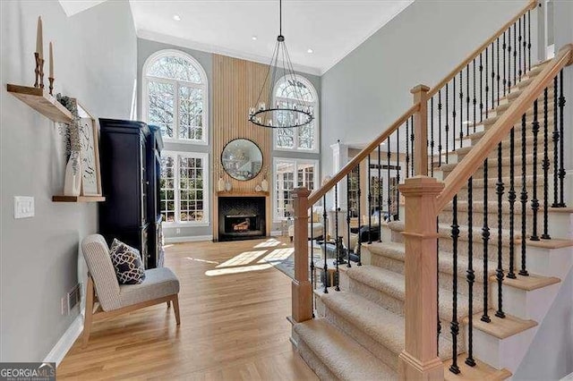 entrance foyer with wood finished floors, a fireplace, baseboards, and stairs