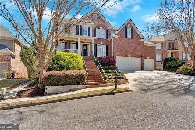 view of front of home featuring brick siding, driveway, a garage, and stairs