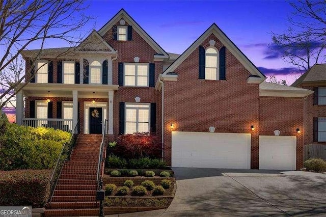 view of front of home featuring covered porch, stairway, brick siding, an attached garage, and concrete driveway