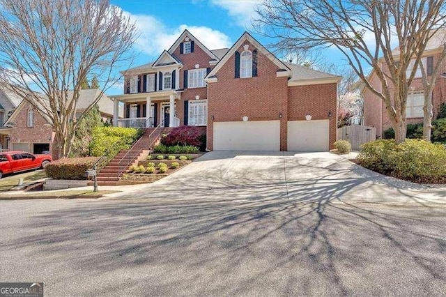 view of front of home with concrete driveway, brick siding, an attached garage, and stairway