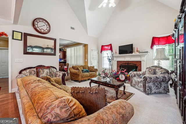 carpeted living area featuring high vaulted ceiling, a ceiling fan, visible vents, and plenty of natural light