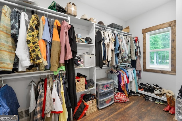 walk in closet with wood finished floors