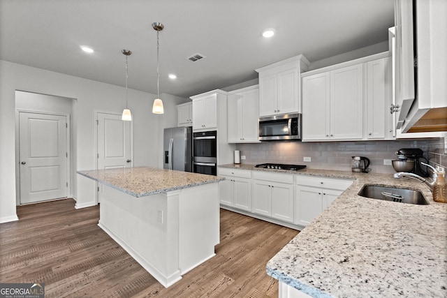 133 Bastian Rd, Mcdonough, GA 30252 - kitchen featuring stainless steel appliances, a center island, wood finished floors, white cabinets, and recessed lighting