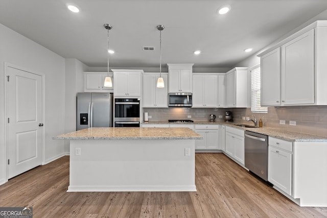 133 Bastian Rd, Mcdonough, GA 30252 - kitchen with stainless steel appliances, a center island, white cabinets, tasteful backsplash, and recessed lighting