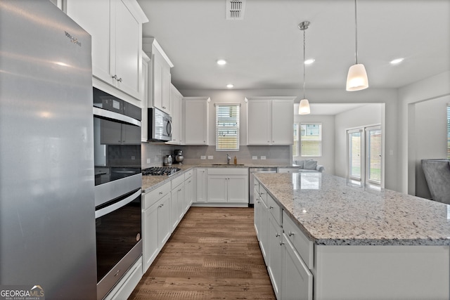 133 Bastian Rd, Mcdonough, GA 30252 - kitchen featuring stainless steel appliances, a kitchen island, recessed lighting, dark wood-type flooring, and decorative backsplash