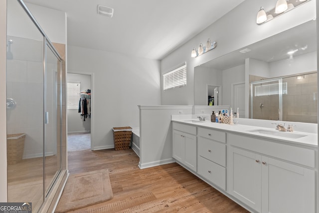 133 Bastian Rd, Mcdonough, GA 30252 - full bathroom featuring a stall shower, double vanity, wood finished floors, and a spacious closet