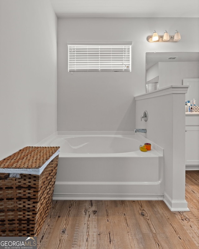 133 Bastian Rd, Mcdonough, GA 30252 - bathroom featuring a bath, wood finished floors, and vanity