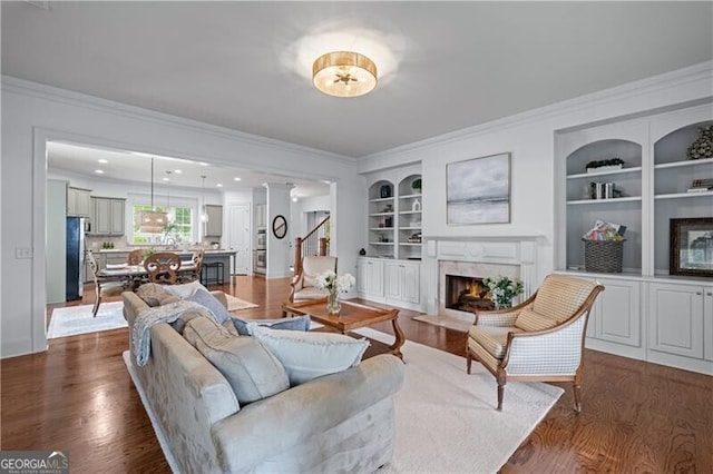 715 Saybeck Way, Milton, GA 30004 - living area featuring crown molding, built in shelves, dark wood-style floors, a fireplace, and baseboards