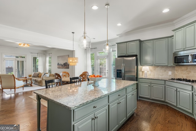 kitchen featuring a breakfast bar area, stainless steel appliances, plenty of natural light, and a center island