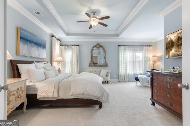 carpeted bedroom with crown molding, ceiling fan, baseboards, a tray ceiling, and visible vents