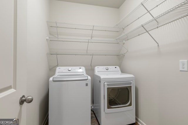laundry room with separate washer and dryer, baseboards, and laundry area