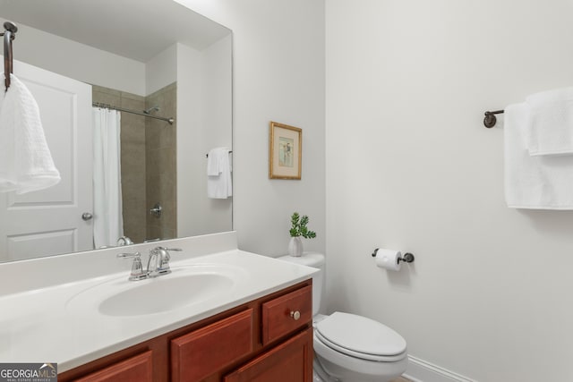 full bathroom featuring toilet, tiled shower, and vanity