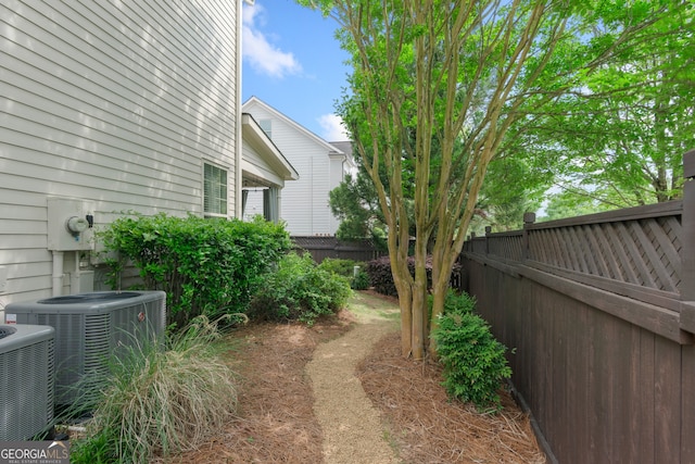 view of yard with a fenced backyard and central AC