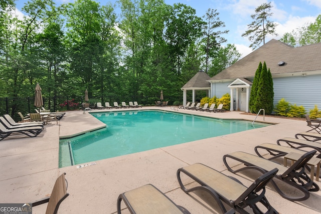 community pool with fence and a patio area