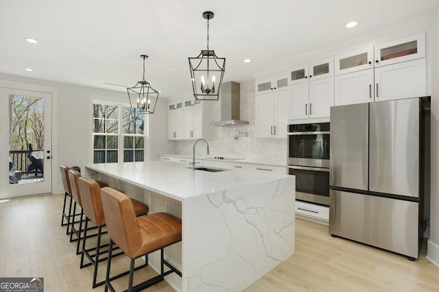 4980 Wildeoak Trl, Douglasville, GA 30135 - kitchen featuring stainless steel appliances, backsplash, white cabinets, a notable chandelier, and wall chimney exhaust hood