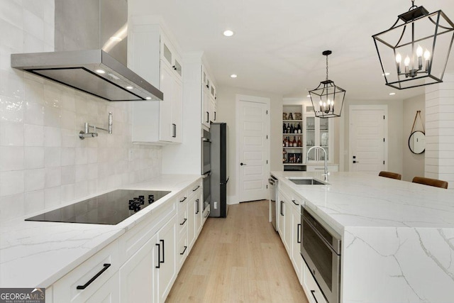 4980 Wildeoak Trl, Douglasville, GA 30135 - kitchen with a notable chandelier, a sink, wall chimney exhaust hood, light wood-style flooring, and stainless steel appliances