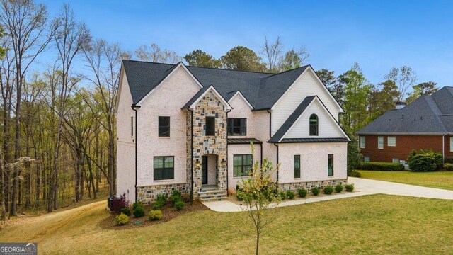 4980 Wildeoak Trl, Douglasville, GA 30135 - view of front of house featuring stone siding, driveway, a standing seam roof, and a front lawn